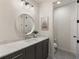 Modern bathroom features a white marble countertop, decorative mirror, and gray vanity at 320 Shady Grove Ln, Alpharetta, GA 30009