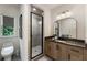 Bright bathroom features a glass shower, stone countertop, and a decorative mirror at 320 Shady Grove Ln, Alpharetta, GA 30009