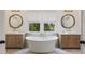 Elegant bathroom with a freestanding tub, dual vanities, and decorative mirrors at 320 Shady Grove Ln, Alpharetta, GA 30009