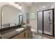 Bathroom with modern fixtures features a glass-enclosed shower, vanity, and a decorative mirror at 320 Shady Grove Ln, Alpharetta, GA 30009