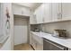 Bright galley kitchen featuring white cabinets, stainless steel appliances, and marble countertops at 320 Shady Grove Ln, Alpharetta, GA 30009