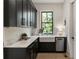Modern kitchen with dark cabinets, marble countertops, stainless steel dishwasher, and a farmhouse sink at 320 Shady Grove Ln, Alpharetta, GA 30009