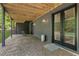 Modern patio with exposed wood ceiling, stone flooring, and black framed glass doors leading to the outdoor space at 320 Shady Grove Ln, Alpharetta, GA 30009
