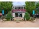 The Cape Restaurant & Beach Bar entrance is framed by lush greenery and vibrant flower accents at 320 Shady Grove Ln, Alpharetta, GA 30009
