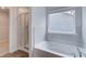Modern bathroom featuring a soaking tub and glass-enclosed shower at 320 Tulip Dr, Covington, GA 30016
