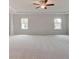 Spacious bedroom with tray ceiling, fan, and large windows at 320 Tulip Dr, Covington, GA 30016