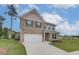 Attractive two-story home with brick and siding, a manicured lawn, and a spacious driveway leading to the garage at 320 Tulip Dr, Covington, GA 30016