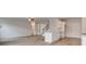 Open concept living space with hardwood floors and stainless steel appliances, and a stylish staircase at 320 Tulip Dr, Covington, GA 30016