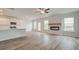 Open-concept living space with sleek flooring, a modern fireplace, and a kitchen with white cabinets at 320 Tulip Dr, Covington, GA 30016