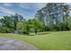 Large backyard featuring a pool house, green grass, and mature trees at 4700 Cascade Sw Rd, Atlanta, GA 30331