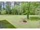 Large grassy backyard featuring a fire pit, mature trees, and green grass at 4700 Cascade Sw Rd, Atlanta, GA 30331