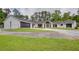 Beautifully renovated white brick home with a modern garage door and lush green lawn in a serene, wooded setting at 4700 Cascade Sw Rd, Atlanta, GA 30331