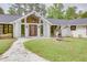 Gorgeous white brick home featuring a modern entrance with a statement art piece and professionally landscaped grounds at 4700 Cascade Sw Rd, Atlanta, GA 30331