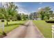 Scenic view of a long driveway leading to a beautiful home, surrounded by lush trees and greenery at 4700 Cascade Sw Rd, Atlanta, GA 30331