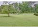 Sprawling green lawn with mature trees, a white fence, and glimpses of a charming property beyond at 4700 Cascade Sw Rd, Atlanta, GA 30331