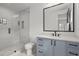 Modern bathroom featuring a sleek glass shower, blue vanity, and stylish fixtures for a spa-like experience at 4785 Merlendale Ct, Atlanta, GA 30327
