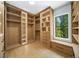 Bright walk-in closet featuring built-in shelving, drawers, and a window offering natural light and scenic views at 4785 Merlendale Ct, Atlanta, GA 30327