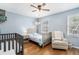 Serene Bedroom featuring light blue walls, hardwood floors, a crib, and a cozy armchair at 6700 Roswell Ne Rd # 25A, Sandy Springs, GA 30328