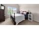 Bright bedroom featuring a wooden bed frame, plush pillows, and natural light streaming through the window at 1181 Gateview Dr, Lawrenceville, GA 30046