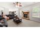 Spacious living room with a stone fireplace, a ceiling fan, and seamless access to the kitchen at 1181 Gateview Dr, Lawrenceville, GA 30046