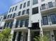 Modern townhouse with white brick facade, dark trim, multiple balconies, and professional landscaping at 1276 Longreen Terrace Nw # 115, Atlanta, GA 30318