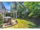 Landscaped backyard with a pergola, grill, and a lush green lawn at 141 Weatherstone Dr, Woodstock, GA 30188