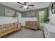Green-themed Bedroom with white wainscoting, two toddler beds, and ample natural light at 141 Weatherstone Dr, Woodstock, GA 30188