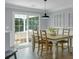 Light and airy dining room with wood floors and access to backyard through sliding glass door at 141 Weatherstone Dr, Woodstock, GA 30188