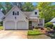 Well-maintained white home featuring a two-car garage and a manicured front yard at 141 Weatherstone Dr, Woodstock, GA 30188