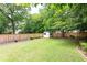 Spacious backyard with a lush lawn, wooden fence, mature trees, and storage shed at 1486 Brooklyn Nw Ave, Atlanta, GA 30309