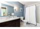 Stylish bathroom with blue wallpaper, a dark wood vanity, and a shower/tub combo with a white curtain at 1486 Brooklyn Nw Ave, Atlanta, GA 30309