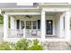 Inviting covered front porch featuring black shutters, white railing, and stylish seating area at 1486 Brooklyn Nw Ave, Atlanta, GA 30309