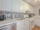 Bright kitchen features white cabinets, modern appliances, decorative tile backsplash and ample countertop space at 2610 Cumberland Ct, Smyrna, GA 30080