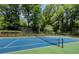 Outdoor tennis court surrounded by lush greenery, providing a private and scenic recreational area at 2610 Cumberland Ct, Smyrna, GA 30080