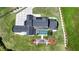 Aerial view showcases a house with a pool, fire pit patio, a large driveway, and manicured lawn at 5160 Howard Rd, Cumming, GA 30040