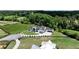 Aerial view of a modern white farmhouse estate featuring a long driveway and professional landscaping surrounded by lush greenery at 5160 Howard Rd, Cumming, GA 30040