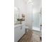 Bathroom featuring brick floors, vanity with white countertop, and tiled shower at 5160 Howard Rd, Cumming, GA 30040