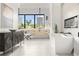Bright bathroom with double vanity, soaking tub, modern fireplace, large windows, and a view of the surrounding landscape at 5160 Howard Rd, Cumming, GA 30040