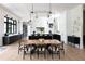 Open dining area with a long wooden table and modern pendant lighting at 5160 Howard Rd, Cumming, GA 30040