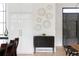 Modern dining area with a unique wall art, a stylish cabinet, and an elegant dark metal front door at 5160 Howard Rd, Cumming, GA 30040