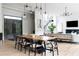 Open-concept dining area with a large wooden table, modern lighting, and views of the staircase at 5160 Howard Rd, Cumming, GA 30040