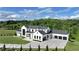 Stunning exterior elevation of a modern farmhouse with a three-car garage and well-manicured lawn at 5160 Howard Rd, Cumming, GA 30040