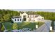 A modern white farmhouse with large windows, black accents, and meticulously landscaped yard in a serene, wooded setting at 5160 Howard Rd, Cumming, GA 30040