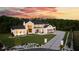 Elegant modern farmhouse with black trim, professional landscaping, and a long driveway highlighted by a colorful dusk sky at 5160 Howard Rd, Cumming, GA 30040