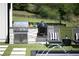 Outdoor built-in BBQ grilling station sits next to a luxury pool and two modern lounge chairs at 5160 Howard Rd, Cumming, GA 30040