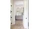 Hallway featuring brick floors, white walls, and a decorative cabinet with arched mirrors at 5160 Howard Rd, Cumming, GA 30040