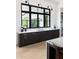 Contemporary kitchen showcasing dark cabinets, a long counter, a sink, and a wall of black-framed windows at 5160 Howard Rd, Cumming, GA 30040
