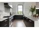 Bright open kitchen with white and dark wood cabinets, stainless steel appliances, and large window at 5160 Howard Rd, Cumming, GA 30040