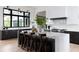 Stylish kitchen boasts an island with seating, white countertops, dark wood cabinets, and a large window at 5160 Howard Rd, Cumming, GA 30040