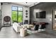 Open living room with sleek seating, TV, and an expansive window showcasing lush greenery at 5160 Howard Rd, Cumming, GA 30040